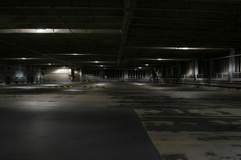 Empty parking deck with a worn floor coating and yellow markings