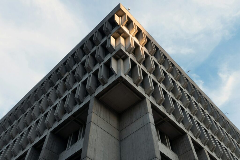 Corner of an exposed-concrete building facade against the sky