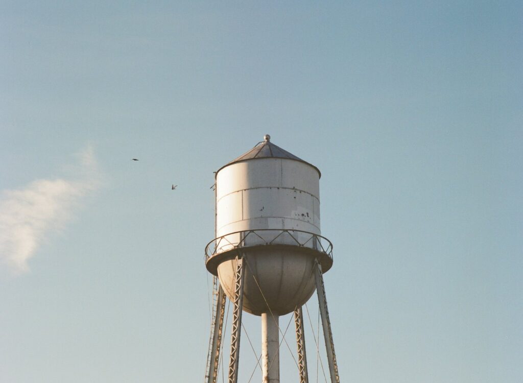White elevated water tower against a pale sky